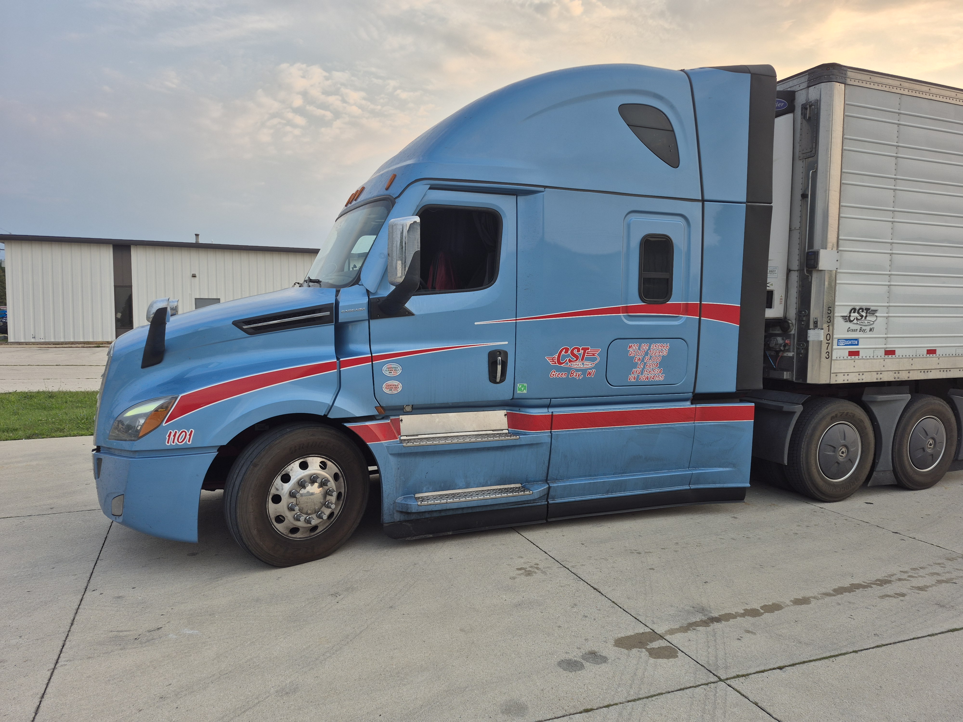 CST Lines light blue sleeper tractor with a white refrigerated trailer at the Green Bay terminal