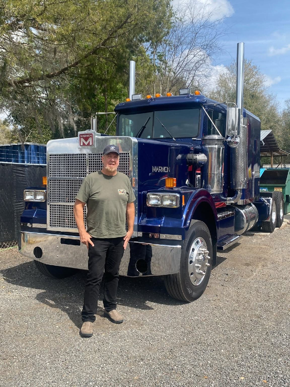 CST Lines owner operator standing in front of his blue Marmon conventional tractor